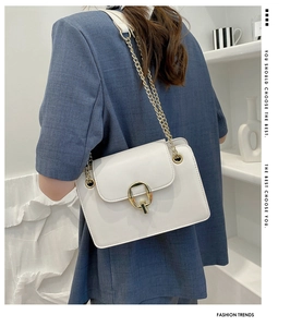 Detailed back view of a white chain crossbody bag with golden ring buckle on a model