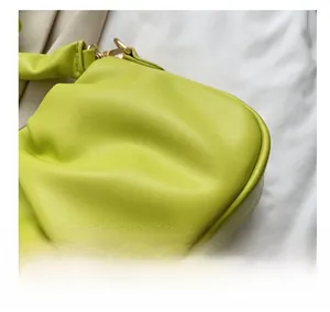 Detailed view of lime green pleated leather texture with elegant gold metal hardware