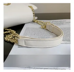 Detail of the comfortable white leather shoulder strap with golden chain and padded support