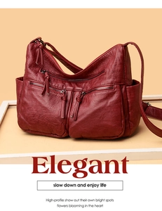 Detailed view of dark red soft faux leather shoulder bag with multiple zippered pockets