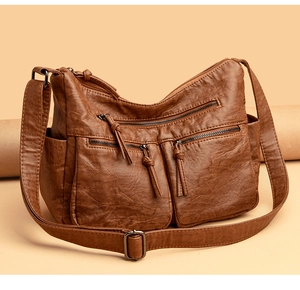 Detail of soft brown PU leather bag with multiple zip pockets and vintage hardware