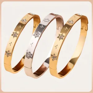 Polished stainless steel star engraved hinged bracelet with inset rhinestones in gold and silver