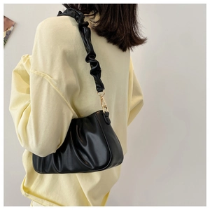 Detail of the pleated shoulder strap with gold metal hook on black cloud bag