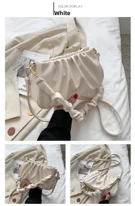 Close-up of white ruched cloud bag showing soft PU leather texture and gold hardware