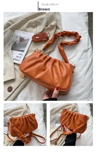 Detail of orange-brown pleated cloud bag showing soft leather texture and handle