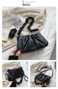 Close-up of black pleated cloud bag with detachable straps and golden metal hardware