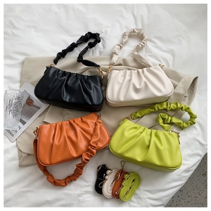 Detail of ruched cloud bags in black, beige, orange, and green with matching straps