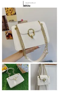 Detailed view of white leather crossbody bag with gold round lock and chain strap
