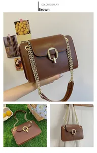 Detail of a brown leather chain bag featuring gold hardware clasp and sleek square design