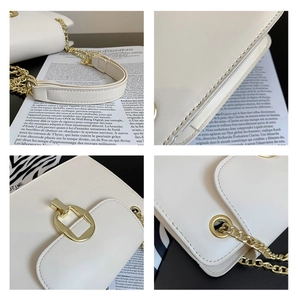 Close-up of white leather crossbody bag showing fine stitching and gold hardware detail