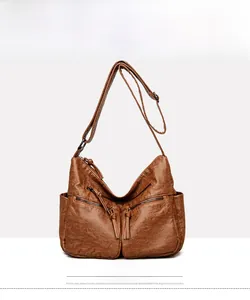 Front detail of yellow-brown soft PU leather handbag with dual zippers and side pockets