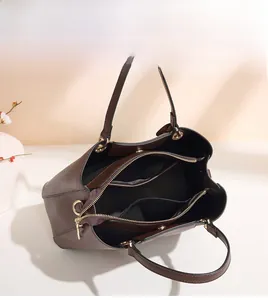 Top-down view of a brown leather handbag showing multi-compartment interior and gold hardware