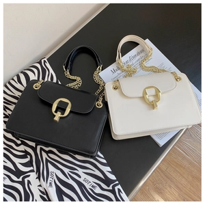 Detail of matte faux leather crossbody bag with elegant gold geometric metal lock