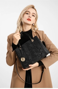 Detailed view of black crocodile pattern handbag with golden F pendant and shoulder strap