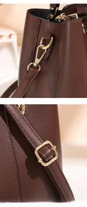 Detail of dark brown lychee grain leather strap with gold metal hooks and adjustable buckle