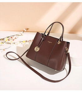 Detail of dark brown litchi pattern tote bag with gold hardware and classic logo