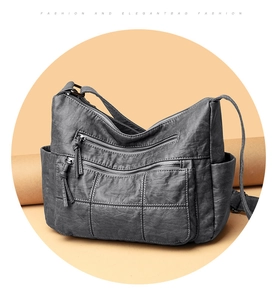Detail of dark grey vintage faux leather crossbody bag with multiple zip pockets