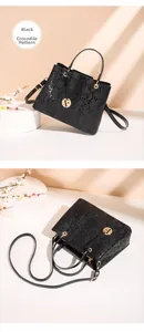 Detail of black crocodile texture handbag featuring golden F charm and top handle