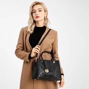 Detail of black faux-reptile leather tote bag with gold F-logo charm and round handles