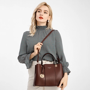 Detail of burgundy pebbled leather handbag with gold F pendant and logo lettering