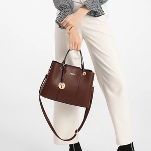 Detail of dark brown leather handbag with gold hardware and Classic & Bag logo