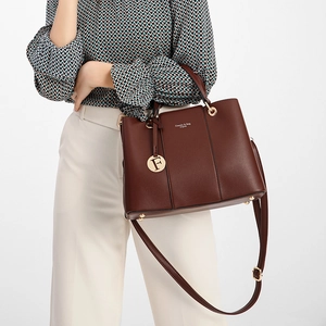Close-up of dark brown handbag with gold F-pendant and Classic & Bag Original logo print