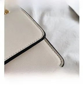 Detail of beige faux leather texture with fine stitching and golden metal chain