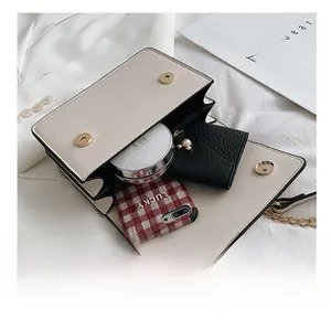 Detail view of the interior compartment of a beige chain bag showing daily essentials