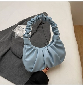 Close-up of soft pleated light blue leather cloud bag with ruched handle detail