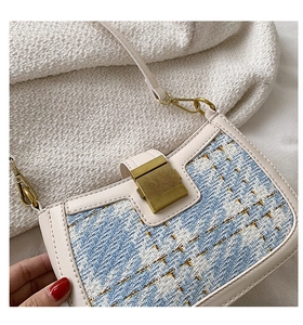 Close-up of blue and white tweed fabric texture with gold metallic thread on lady handbag