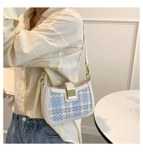 Side view of elegant blue tweed underarm bag with gold buckle on a shoulder strap