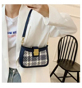Detail of navy blue leather trim and black-white tweed fabric on a round shoulder bag