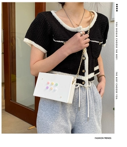 Schicke weiße Box-Tasche mit 3D-Blumenakzenten und Goldkette, am Modell getragen