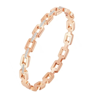 Macro detail of rose gold link bracelet featuring micro-pave white crystal embellishments
