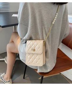 Beige quilted leather mini bag with elegant pearl chain and metallic clasp detail