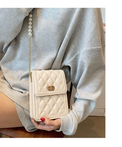 Detail of cream quilted mobile phone bag with pearl chain strap and metal clasp