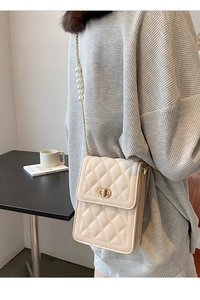 Detailed view of quilted faux leather phone bag with elegant pearl chain and gold hardware