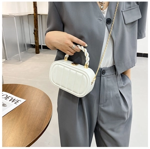 Detail of white quilted leather mini bag with gold chain strap and top handle