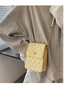 Detail of cream quilted mobile phone bag with gold metal lock and pearl chain strap
