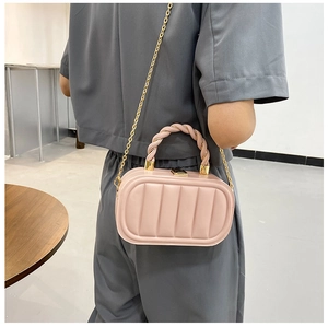 Detail of pink oval handbag with pleated faux leather texture and gold chain strap