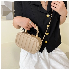 Detailed view of beige structured handbag with vertical stripes and woven handle