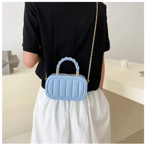 Detail of light blue box-shaped handbag with vertical texture and golden chain strap