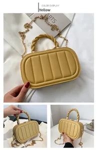 Detail of yellow textured leather handbag with gold twisted handle and chain strap