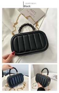 Close-up of black quilted handbag with twisted handle and gold chain detail