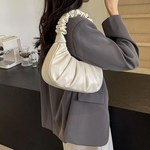 Chic white pleated cloud bag with scrunchie strap shown as a stylish underarm shoulder bag