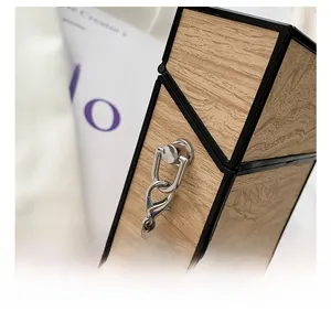 Close-up of wood grain textured box bag with black trim and silver chain strap