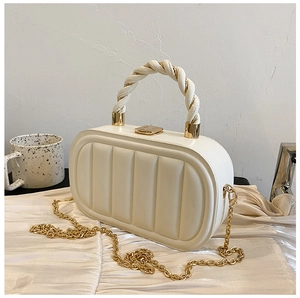 Detail of white quilted oval handbag with twisted leather-gold handle and chain strap