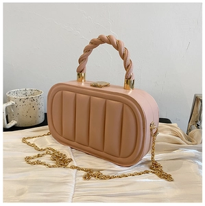 Detail of pink quilted handbag featuring woven rope handle and gold chain strap