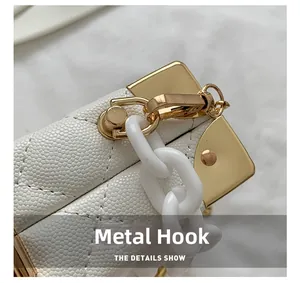Detailed close-up of white pebble leather bag with gold hardware and acrylic chain
