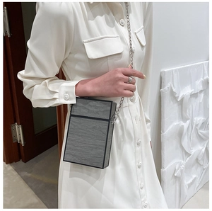 Close-up of hard shell crossbody bag with dark grey marble texture and silver chain